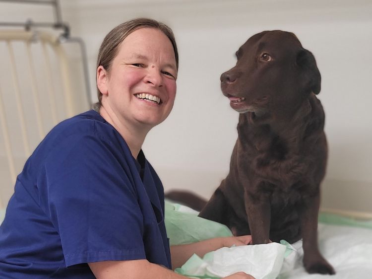 Portrait von Esther Haßdenteufel mit einem Labrador. 